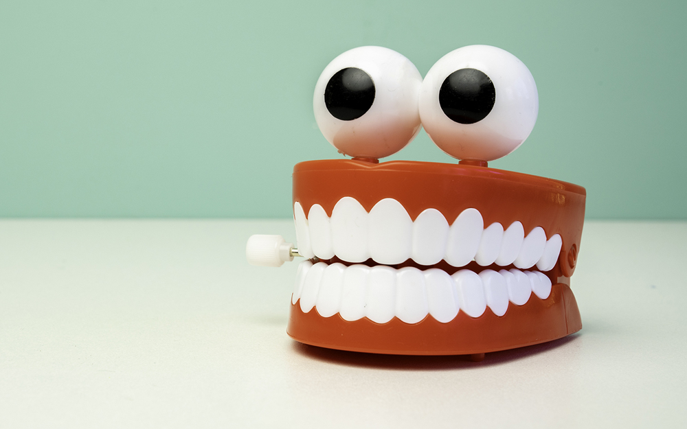 A novelty teeth model with oversized eyes, representing the symptoms of night-time teeth grinding, bruxism.