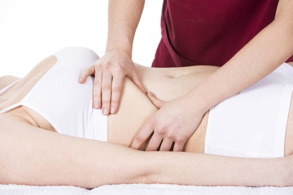 Therapist performing a specialised massage on a client's thoracoabdominal diaphragm, using techniques to relax and work the muscle that separates the chest and abdominal cavities.